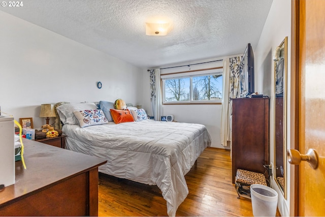 bedroom with wood-type flooring and a textured ceiling