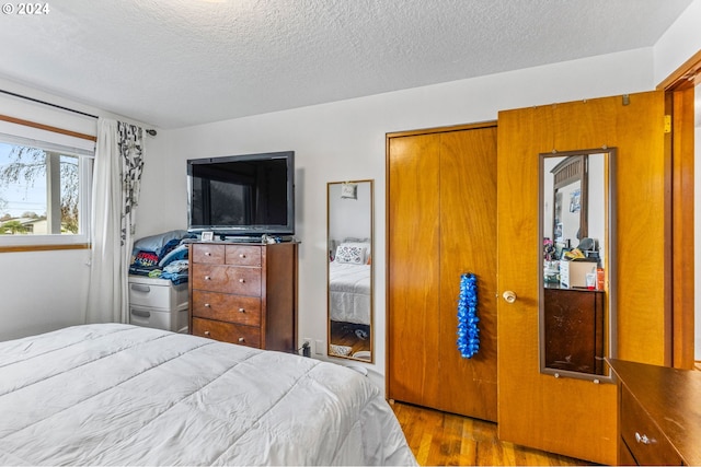 bedroom featuring a textured ceiling and light wood-type flooring