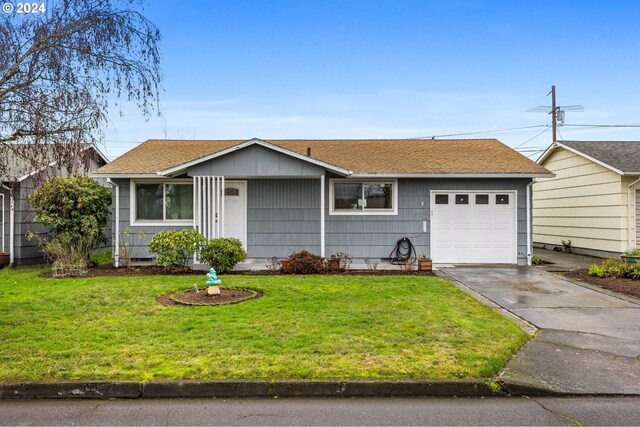 ranch-style house featuring a garage and a front lawn