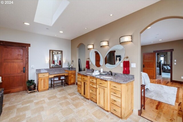 bathroom featuring vanity and a skylight