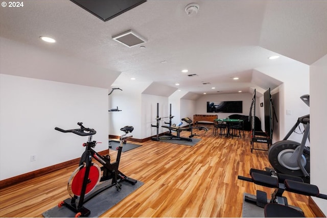 exercise room with hardwood / wood-style flooring and a textured ceiling