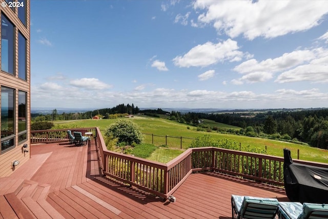 deck featuring a lawn and a rural view