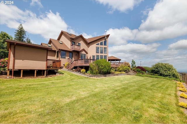 rear view of house with a wooden deck and a lawn