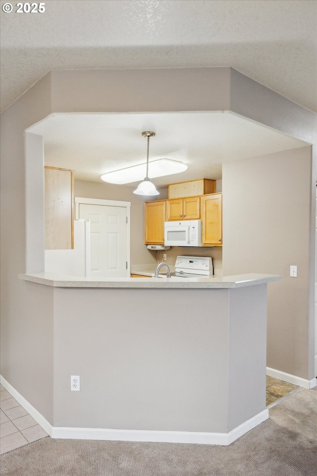 kitchen with light brown cabinetry, light colored carpet, kitchen peninsula, and white appliances