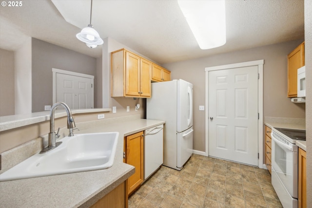 kitchen featuring white appliances, a textured ceiling, decorative light fixtures, light brown cabinetry, and sink