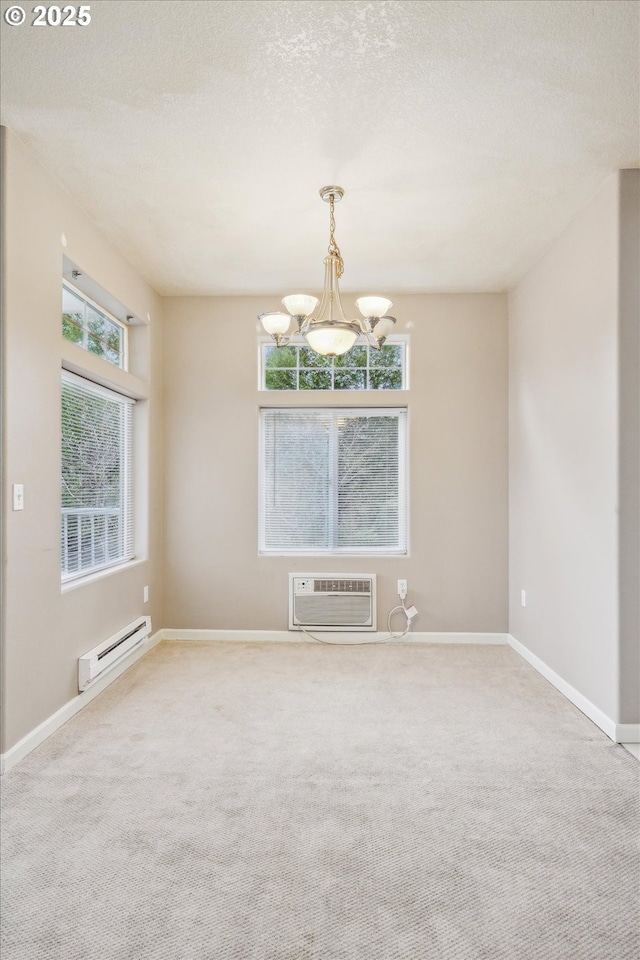 carpeted empty room with a baseboard heating unit, a textured ceiling, a wall mounted AC, and a notable chandelier