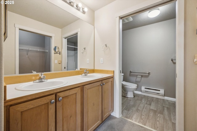 bathroom featuring toilet, baseboard heating, hardwood / wood-style floors, and vanity