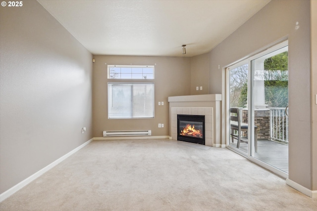 unfurnished living room featuring light colored carpet, plenty of natural light, a tile fireplace, and a baseboard radiator