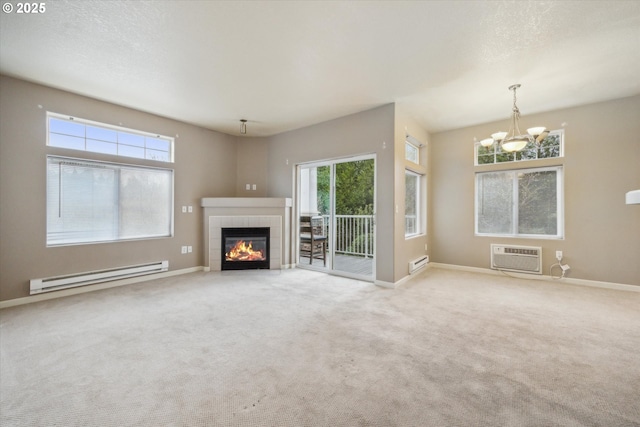 unfurnished living room featuring a baseboard heating unit, a notable chandelier, a wall unit AC, and a tiled fireplace