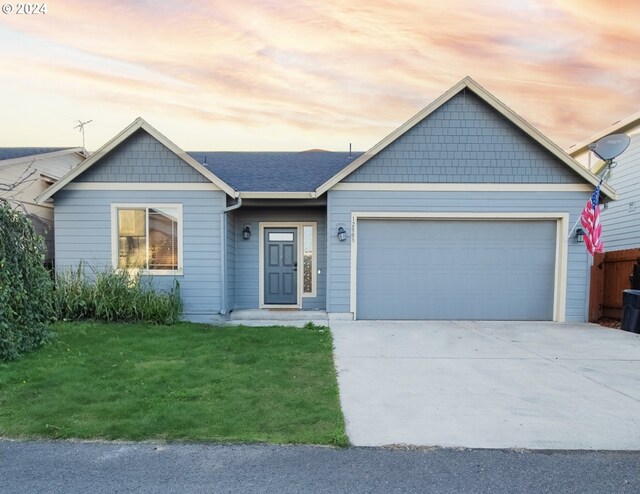 view of front of home with a yard and a garage