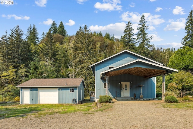 exterior space with a garage, covered porch, and an outbuilding