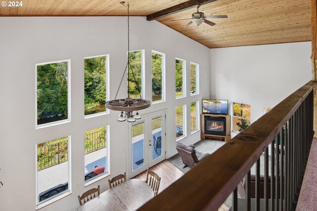 staircase featuring high vaulted ceiling, ceiling fan with notable chandelier, wood-type flooring, wooden ceiling, and beam ceiling