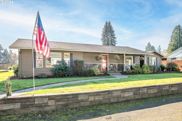 single story home featuring a porch and a front lawn