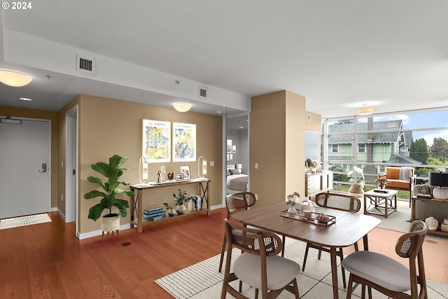 dining room featuring baseboards, visible vents, and wood finished floors