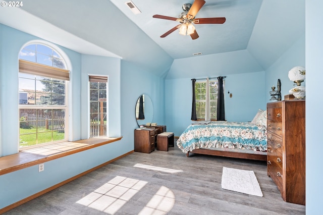 bedroom with ceiling fan, vaulted ceiling, and wood-type flooring