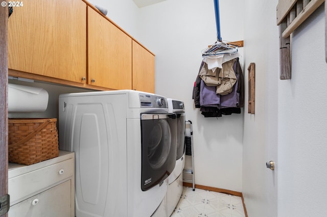 washroom featuring washer and clothes dryer and cabinets