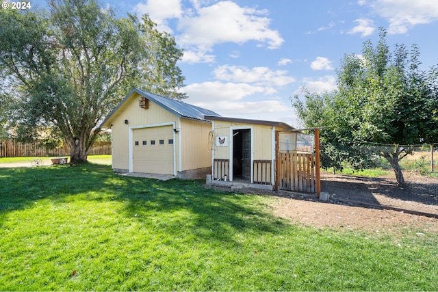 view of front of house featuring a garage, a front lawn, and an outbuilding