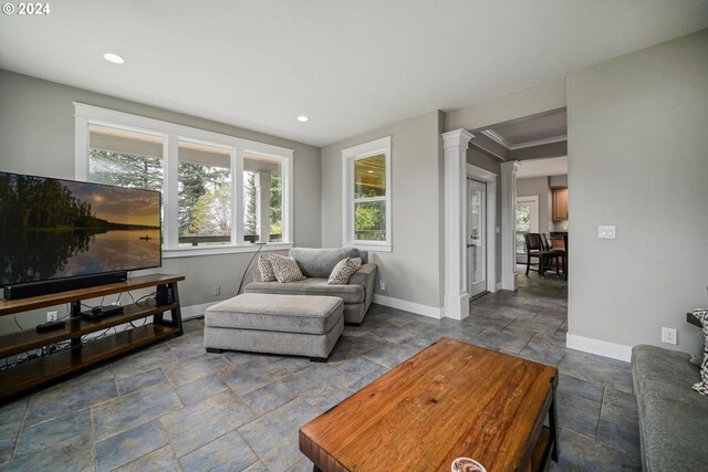 living room featuring decorative columns and crown molding