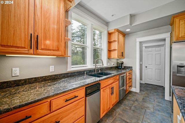 kitchen featuring a sink, open shelves, stone finish flooring, stainless steel fridge, and baseboards