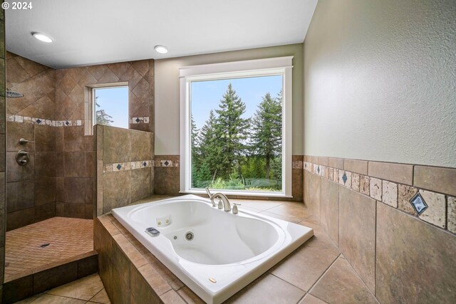 bathroom with tile walls, independent shower and bath, and tile patterned floors