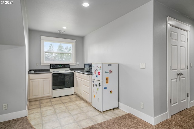 kitchen with light colored carpet, white appliances, and white cabinets