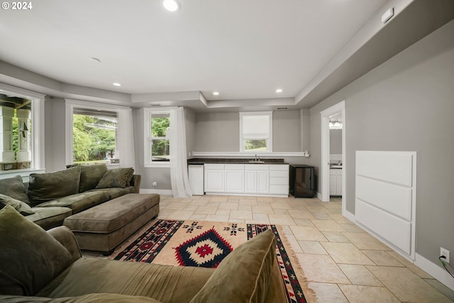 living room with stone finish floor, recessed lighting, and baseboards