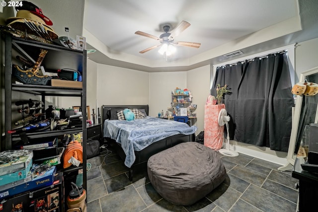 bedroom with visible vents, ceiling fan, and a tray ceiling