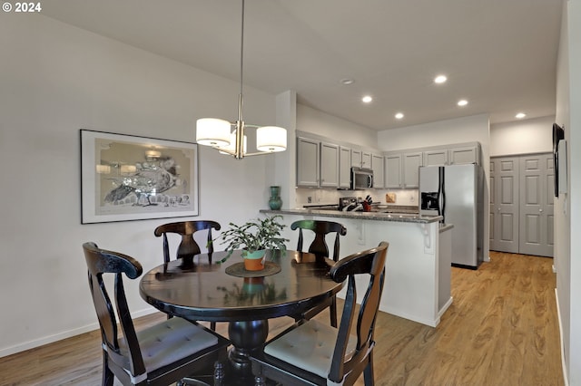 dining room with a chandelier and light hardwood / wood-style flooring