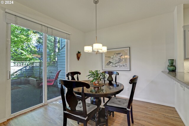 dining space with hardwood / wood-style floors and an inviting chandelier