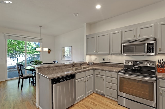 kitchen featuring light hardwood / wood-style flooring, stainless steel appliances, and kitchen peninsula