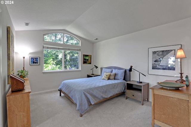 bedroom featuring lofted ceiling and light carpet