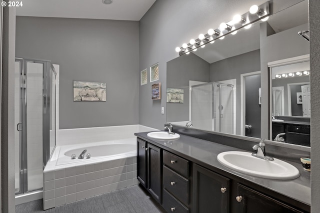 bathroom with vanity, vaulted ceiling, independent shower and bath, and tile patterned flooring