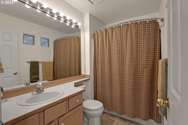 bathroom featuring tile patterned floors, toilet, a shower with curtain, vanity, and a textured ceiling