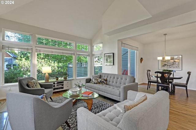 living room featuring hardwood / wood-style floors, high vaulted ceiling, and an inviting chandelier