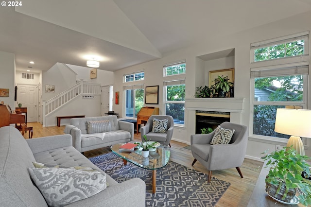 living room with high vaulted ceiling and hardwood / wood-style flooring