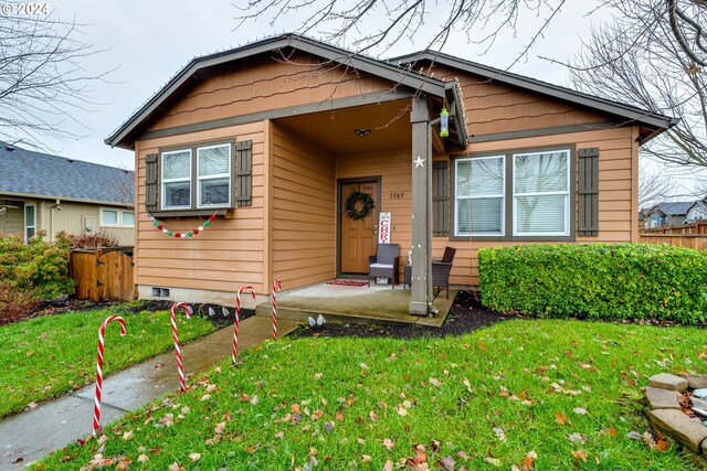 bungalow-style home with a front yard and a patio area