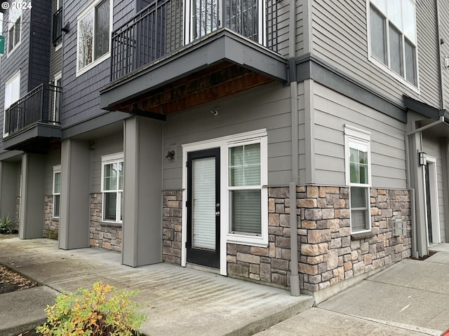 view of exterior entry featuring a balcony