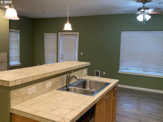 kitchen featuring tile counters, sink, a center island, dark wood-type flooring, and decorative light fixtures