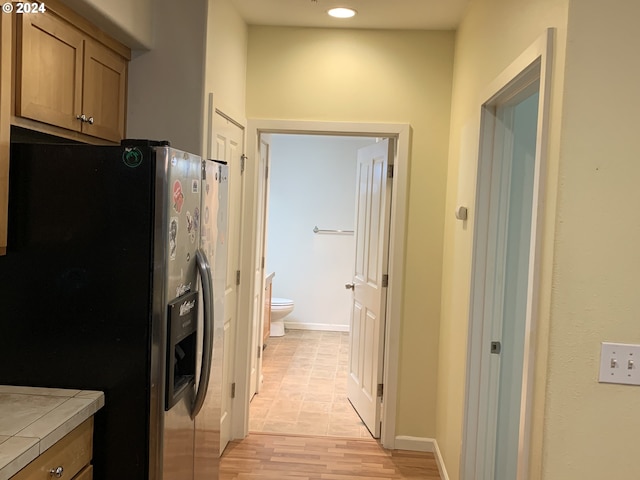 10733 NE Red Wing Way Unit 101, Hillsboro, OR 97006 - kitchen with stainless steel fridge, tile countertops, and light wood finished floors