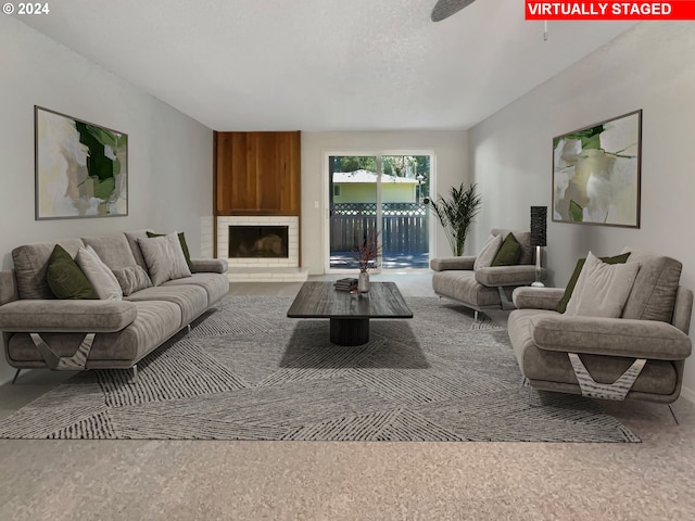 carpeted living room featuring a fireplace and ceiling fan