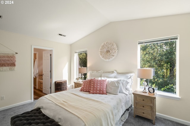 carpeted bedroom featuring vaulted ceiling and connected bathroom