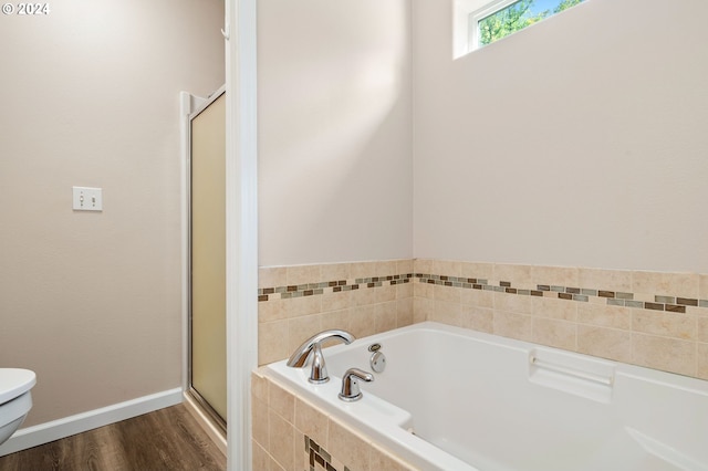 bathroom with wood-type flooring, separate shower and tub, and toilet