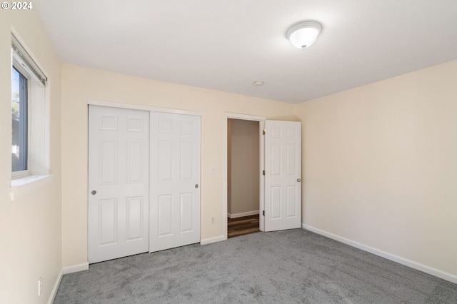 unfurnished bedroom featuring a closet and light colored carpet