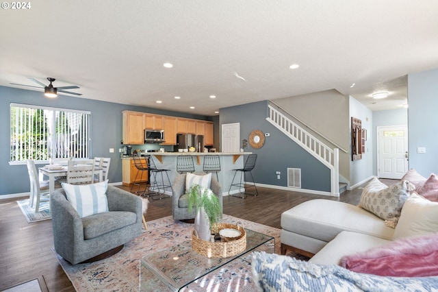 living room with dark hardwood / wood-style floors and ceiling fan