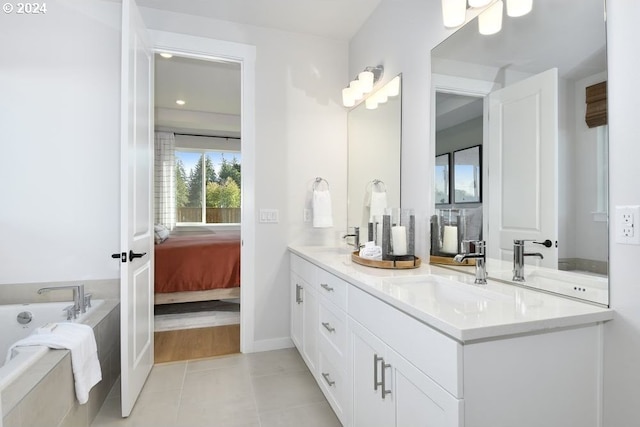 bathroom with tile patterned floors, a tub, and vanity