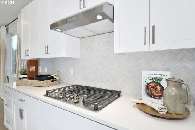 kitchen featuring white cabinets, stainless steel gas stovetop, and decorative backsplash