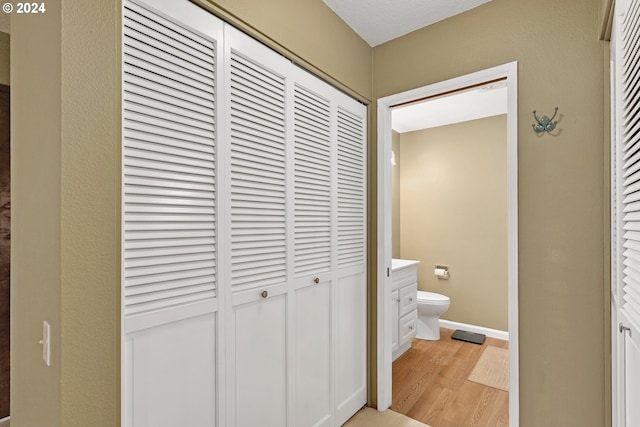 bathroom with hardwood / wood-style floors, vanity, and toilet