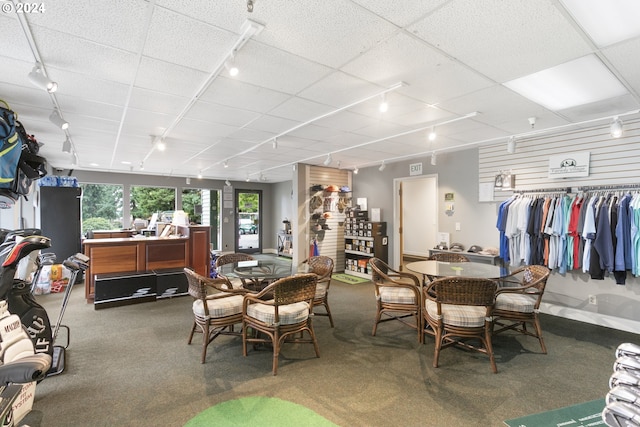 dining space featuring a paneled ceiling, rail lighting, and carpet