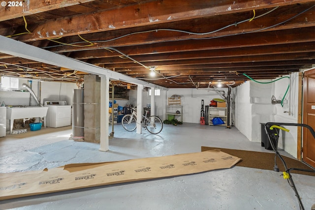 basement with water heater, washing machine and clothes dryer, and sink