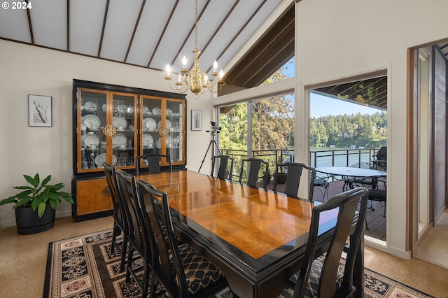 dining space with a chandelier, a water view, and high vaulted ceiling